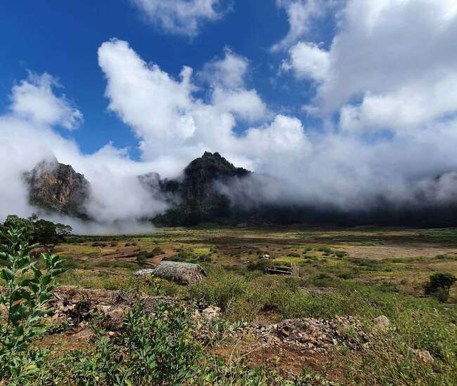 Blauer Himmel, grüne Pflanzen und weiße Wolken im Cova-Krater auf Santo Antão