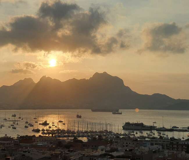 Im Vordergrund die Marina von Mindelo, im Hintergrund der Sonnenuntergang über Santo Antão