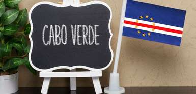 Tafel mit Schriftzug Cabo Verde und daneben eine Kapverden-Flagge