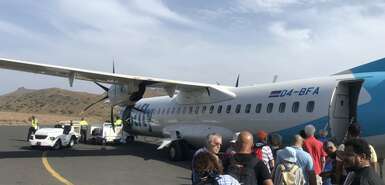 Bestfly-Maschine mit Touristen und Einheimischen davor