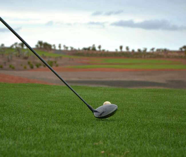 Golfschläger und Golfball auf dem grünen Rasen