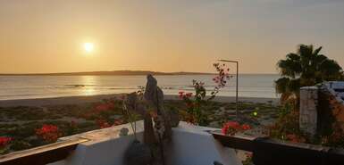 Blick von einer Dachterrasse auf den Sonnenuntergang über dem Meer